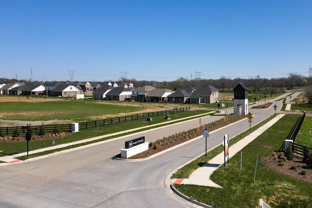 view of property's community with a residential view, fence, and a yard