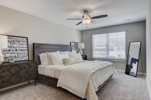 carpeted bedroom featuring a ceiling fan, visible vents, and baseboards