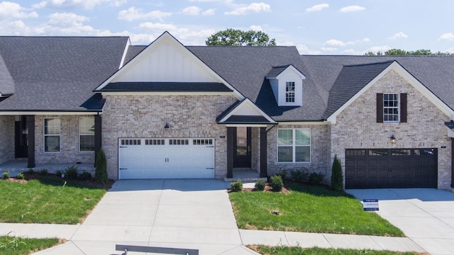 view of front of house with concrete driveway, brick siding, board and batten siding, and a front yard