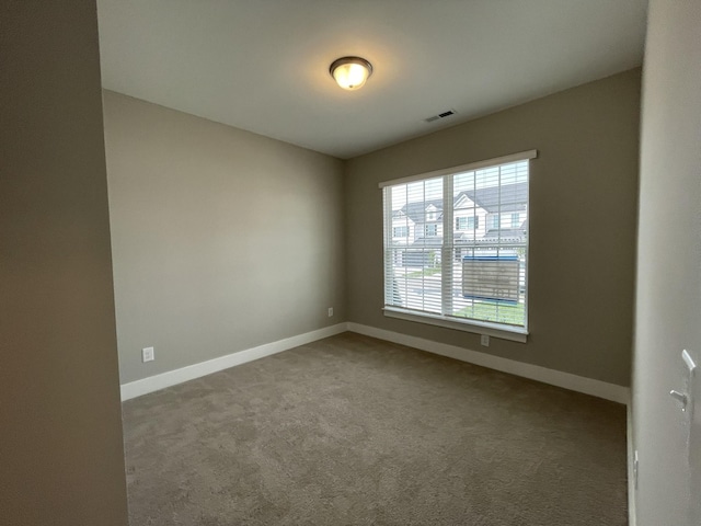 carpeted empty room with baseboards and visible vents