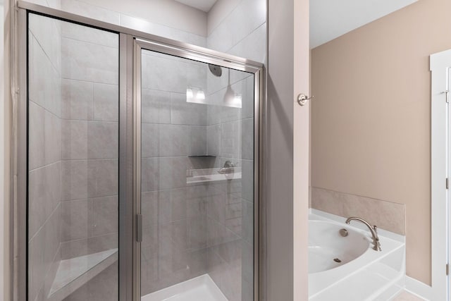 bathroom with a garden tub and a shower stall