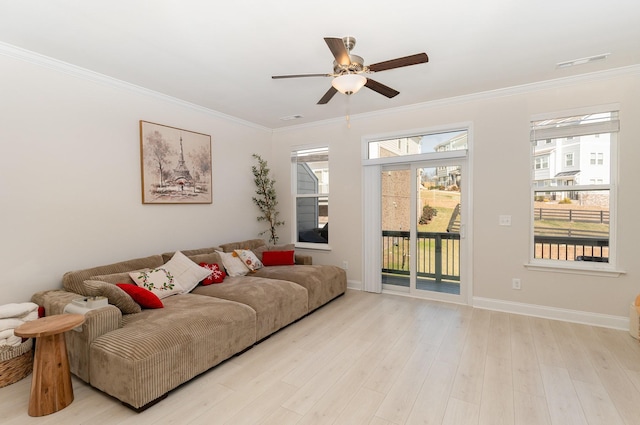 living room featuring baseboards, light wood-style flooring, visible vents, and crown molding