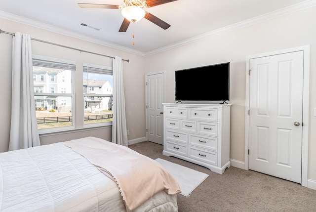 bedroom featuring crown molding, baseboards, visible vents, and light colored carpet