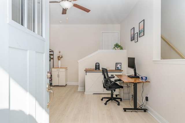 office area with light wood-style floors, baseboards, and a ceiling fan