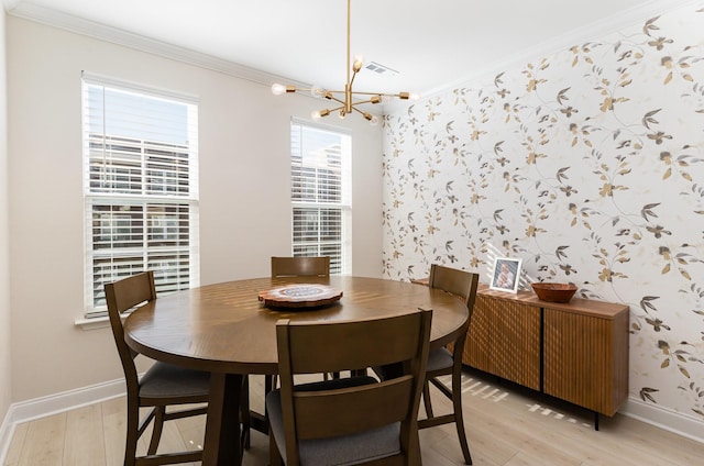 dining room with wallpapered walls, baseboards, visible vents, and ornamental molding