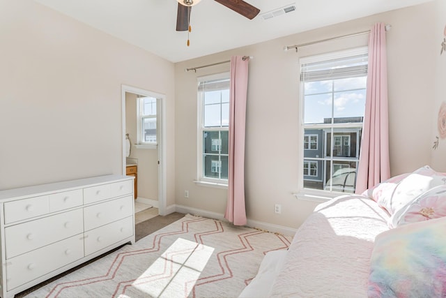 bedroom featuring a ceiling fan, visible vents, baseboards, and multiple windows