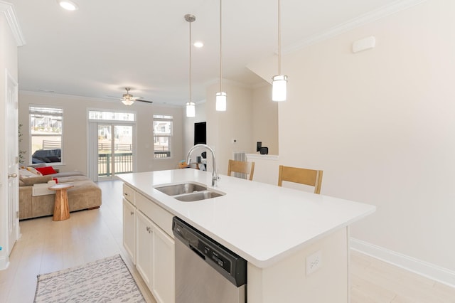 kitchen with stainless steel dishwasher, open floor plan, a kitchen island with sink, a sink, and white cabinets