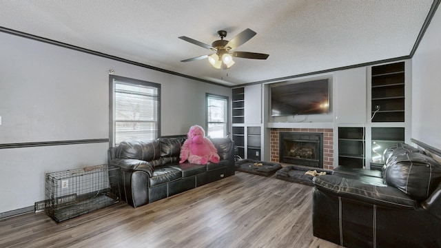 living room with a textured ceiling, built in shelves, and wood finished floors