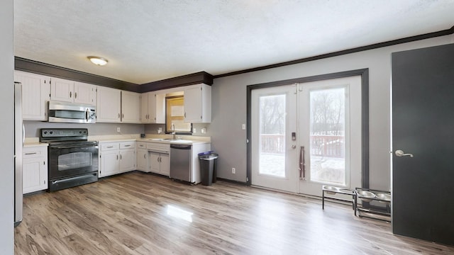 kitchen with appliances with stainless steel finishes, white cabinets, and light countertops