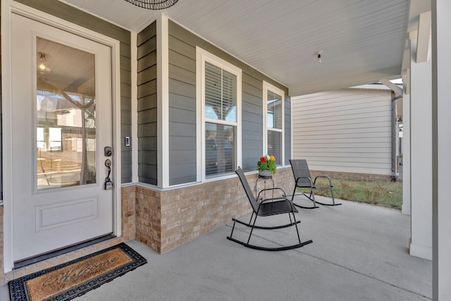 doorway to property with covered porch and stone siding