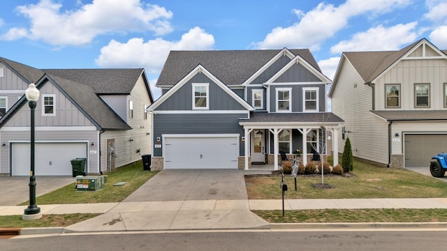 craftsman-style home with a garage, driveway, a porch, board and batten siding, and a front yard