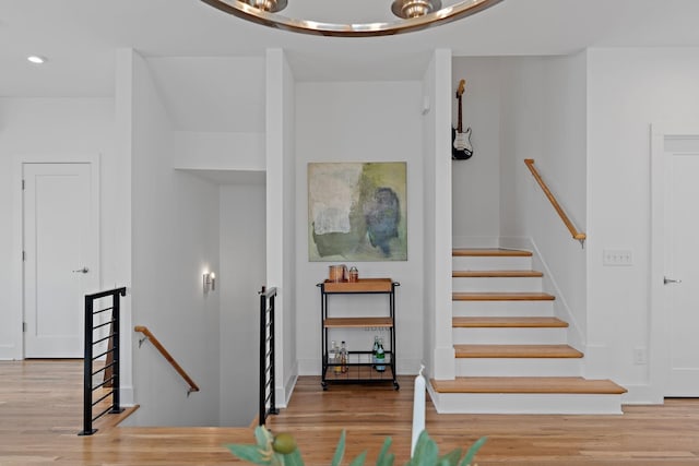 stairs featuring recessed lighting and wood finished floors