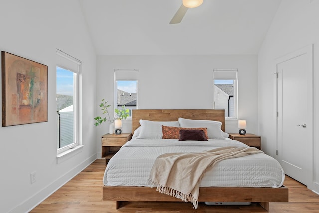 bedroom featuring light wood-style floors, lofted ceiling, ceiling fan, and baseboards