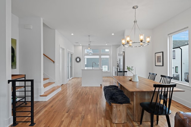 dining space with recessed lighting, baseboards, stairway, and light wood finished floors