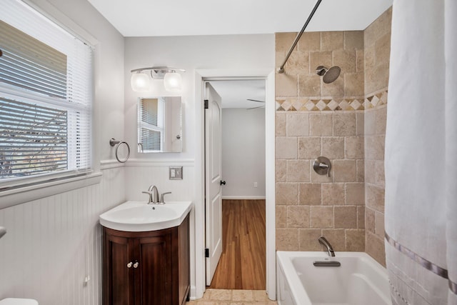 full bath featuring wainscoting, vanity, and shower / tub combo with curtain