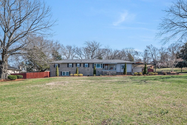 ranch-style house with a front lawn and fence