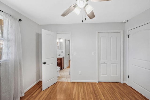 unfurnished bedroom featuring light wood-style floors, ceiling fan, baseboards, and a closet