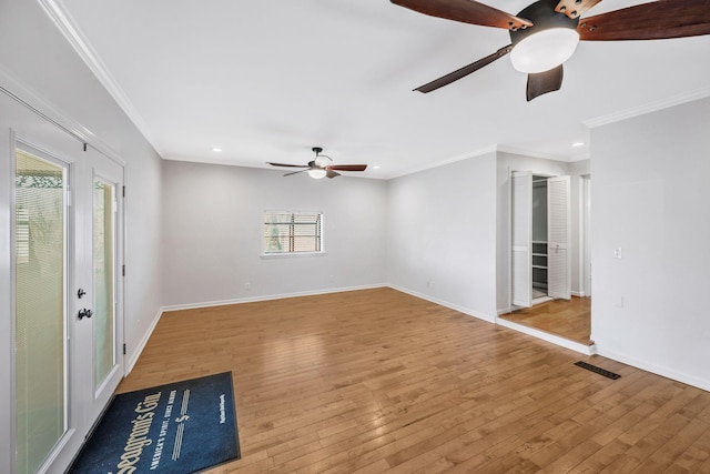 unfurnished room with visible vents, baseboards, ceiling fan, crown molding, and light wood-type flooring