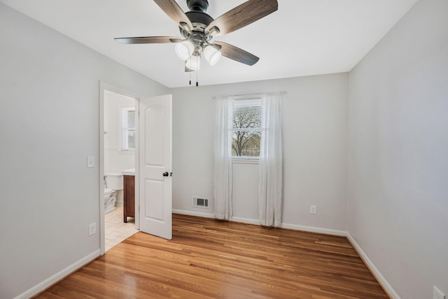 unfurnished bedroom with visible vents, light wood-style flooring, and baseboards