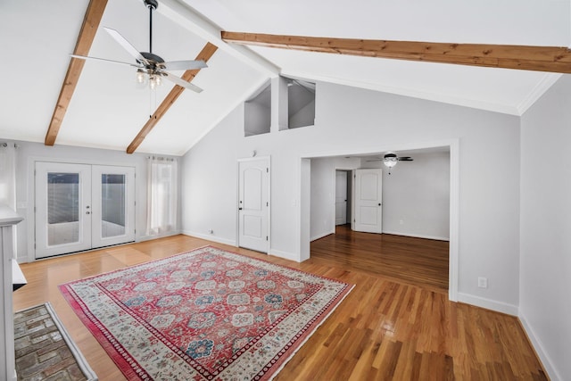 unfurnished living room featuring light wood-style floors, french doors, baseboards, and beam ceiling