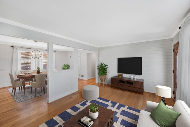 living room featuring a chandelier, wood finished floors, and ornamental molding