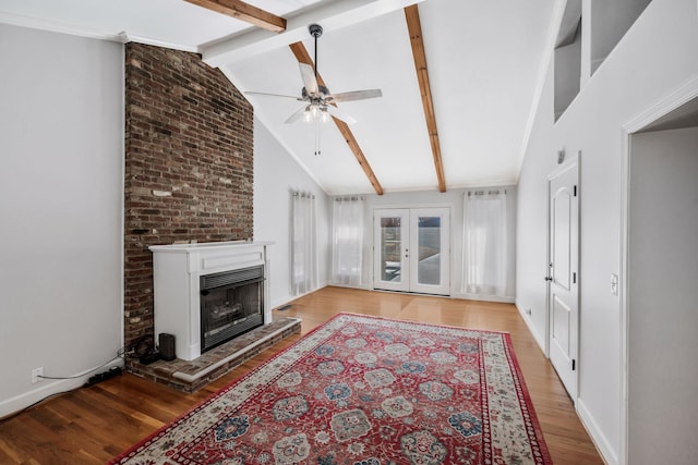 living area with french doors, a fireplace with raised hearth, lofted ceiling with beams, light wood-style floors, and ceiling fan