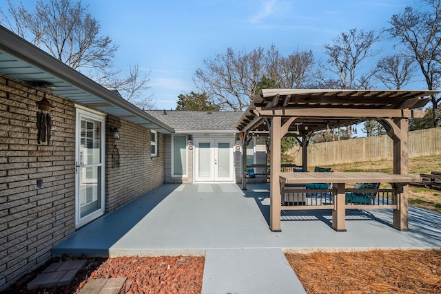 view of patio with french doors, fence, and a pergola