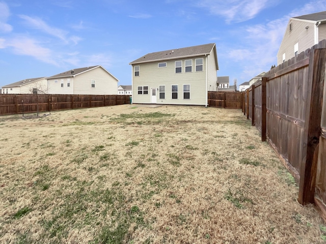 rear view of property with a fenced backyard and a residential view