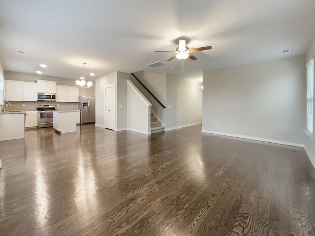 unfurnished living room featuring stairway, baseboards, visible vents, and dark wood-style flooring