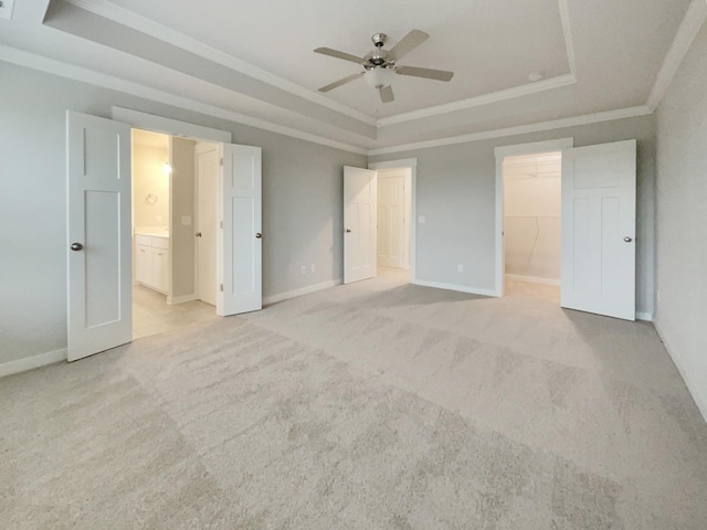 unfurnished bedroom featuring light carpet, a raised ceiling, and crown molding