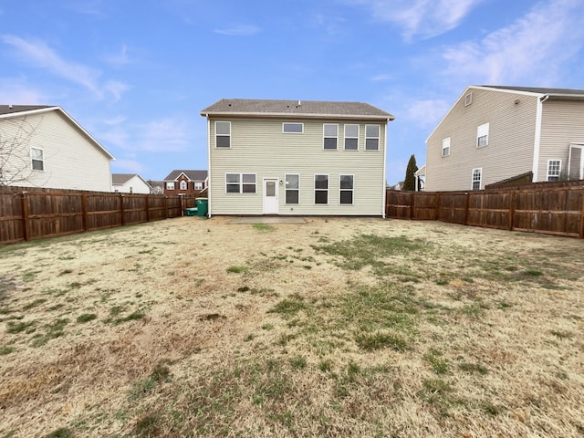 rear view of house with a yard and a fenced backyard