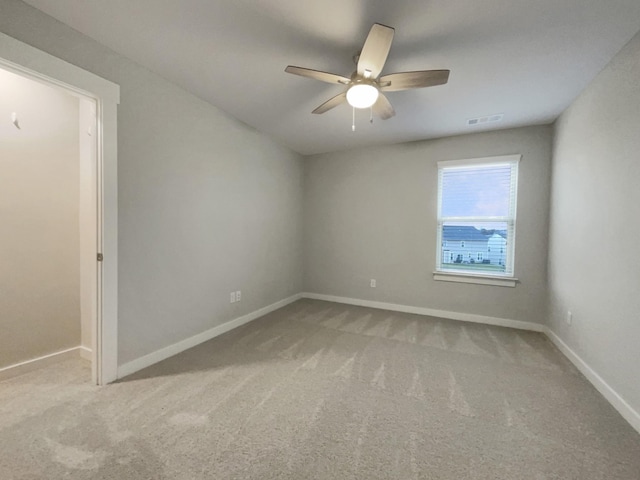 unfurnished room with baseboards, a ceiling fan, visible vents, and light colored carpet