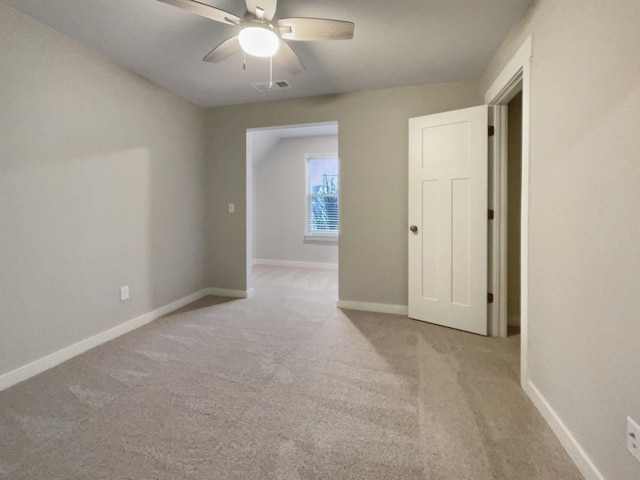 unfurnished room featuring baseboards, ceiling fan, visible vents, and light colored carpet