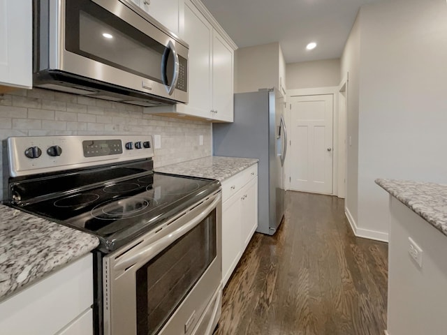 kitchen featuring dark wood-style flooring, white cabinetry, stainless steel appliances, and light stone counters