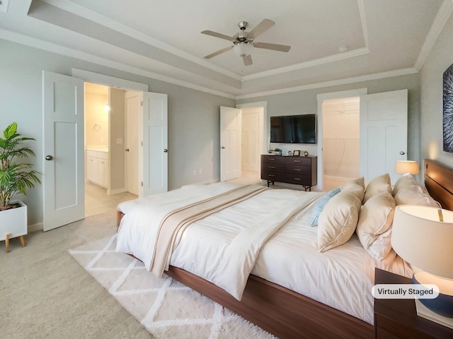 bedroom featuring ornamental molding, a raised ceiling, light carpet, and ensuite bathroom