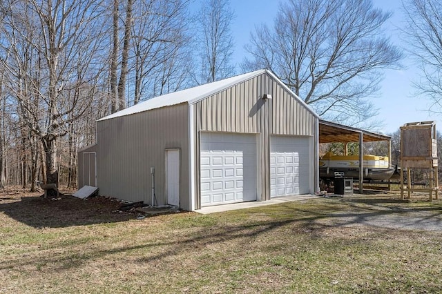 garage with driveway and a detached garage