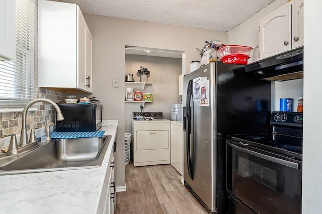 kitchen with under cabinet range hood, light countertops, black appliances, white cabinetry, and a sink