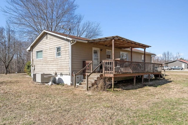 view of front of property with stairs, a front yard, a wooden deck, and cooling unit