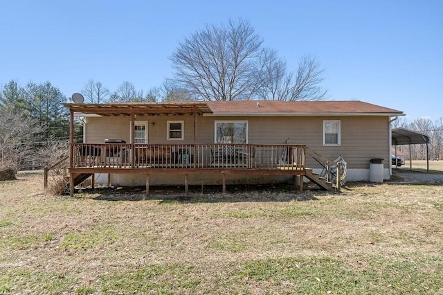 back of house featuring stairway, a lawn, a wooden deck, and a detached carport