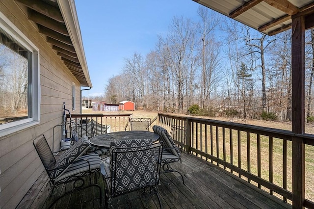 wooden deck with a shed and outdoor dining area