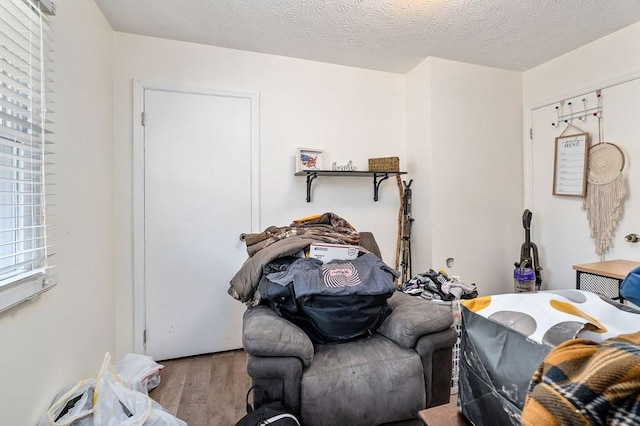 bedroom with a textured ceiling and wood finished floors