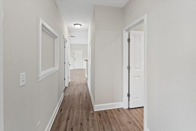 hallway featuring light wood-style floors and baseboards