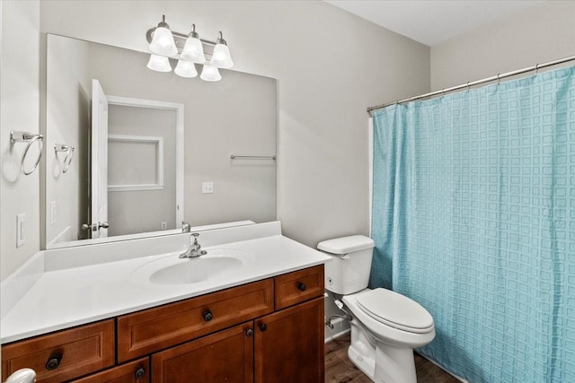 bathroom featuring toilet, a shower with curtain, wood finished floors, and vanity