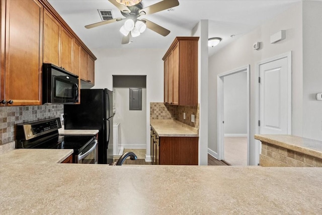 kitchen featuring tasteful backsplash, visible vents, brown cabinets, light countertops, and black appliances