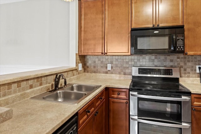 kitchen featuring a sink, black appliances, backsplash, and light countertops