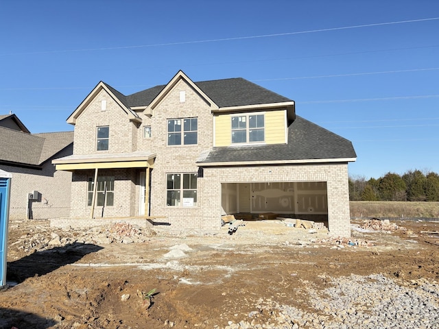 view of front of home featuring a garage, brick siding, and a shingled roof