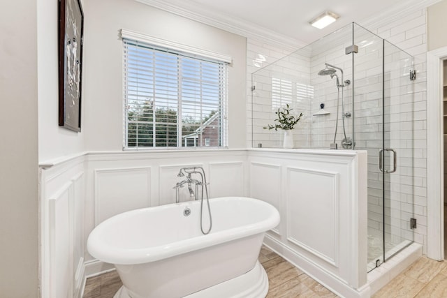 bathroom with a wainscoted wall, a soaking tub, a shower stall, and a decorative wall