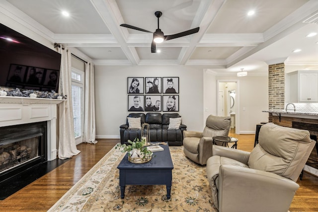 living area featuring a fireplace with flush hearth, coffered ceiling, wood finished floors, and beamed ceiling