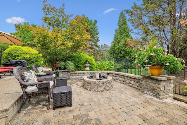 view of patio / terrace with a fire pit and fence