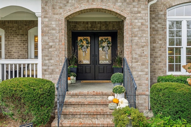 property entrance with french doors and brick siding